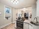 Well-lit kitchen with tiled floors, stainless steel sink, breakfast bar, and white cabinets, creating a clean and efficient space at 1612 N High St, Denver, CO 80218