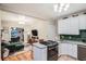 Open-concept kitchen and living area with stainless steel appliances and comfortable seating at 1612 N High St, Denver, CO 80218