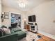 Cozy living room with a plush green couch, entertainment center, and hardwood floors, perfect for relaxation and entertaining at 1612 N High St, Denver, CO 80218