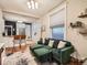 Inviting living room with a green sectional sofa, hardwood floors, and abundant natural light from the large window at 1612 N High St, Denver, CO 80218