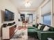 Comfortable living room with open layout to the kitchen, featuring a green sectional sofa and modern entertainment unit at 1612 N High St, Denver, CO 80218