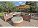 Inviting backyard seating area with a circular sofa around a fire pit and a shade umbrella at 17490 W 67Th Ave, Arvada, CO 80007