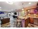 Wet bar area in basement featuring pendant lighting, granite countertops, and wooden cabinetry at 17490 W 67Th Ave, Arvada, CO 80007