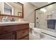 Neutral toned bathroom featuring a glass shower enclosure and wood vanity with stone countertop at 17490 W 67Th Ave, Arvada, CO 80007