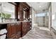 Bathroom boasts dark wood cabinetry, double sinks, and a glass-enclosed shower at 17490 W 67Th Ave, Arvada, CO 80007