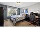 This bedroom has a neutral paint color, large window, carpeted floor, and a sports-themed decoration at 17490 W 67Th Ave, Arvada, CO 80007