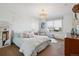 Bright bedroom featuring a large window, soft carpet, and decorative chandelier lighting at 17490 W 67Th Ave, Arvada, CO 80007