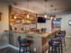 Basement bar features wooden shelving, brick backsplash, and leather barstool seating at 5893 Lasso Pl, Parker, CO 80134