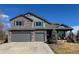 Beautiful two-story home featuring stone accents, three-car garage, and covered front porch at 5893 Lasso Pl, Parker, CO 80134