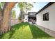 Expansive backyard features lush green lawn, mature trees, and a modern patio, offering a private outdoor space at 1462 S Vine St, Denver, CO 80210