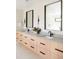 A double vanity in the bathroom with framed mirrors, black faucets, and light wood drawers adds a luxurious feel at 1462 S Vine St, Denver, CO 80210