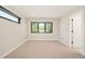 A bright bedroom provides an open and inviting space featuring neutral-toned carpet and a large window at 1462 S Vine St, Denver, CO 80210
