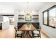 Modern dining room features a wood table, stylish chandelier, and dark cabinetry with beverage cooler and marble accents at 1462 S Vine St, Denver, CO 80210