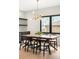 Bright dining room boasts a wood table, modern light fixture, and black trimmed window with a view of the neighborhood at 1462 S Vine St, Denver, CO 80210