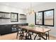 Bright dining room with wood table, stylish chandelier, dark cabinets, beverage cooler, open shelving, and a sun-filled window at 1462 S Vine St, Denver, CO 80210