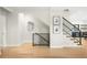 Bright and airy entryway showcasing hardwood floors and a modern staircase with black railings at 1462 S Vine St, Denver, CO 80210