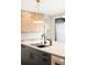 Kitchen featuring sleek island, black sink, light wood cabinets, and door to the outside at 1462 S Vine St, Denver, CO 80210