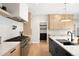 Bright kitchen with light wood cabinets, stainless appliances, and a center island with black countertops and a black sink at 1462 S Vine St, Denver, CO 80210