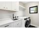Well-appointed laundry room featuring modern washer and dryer, countertop, and black fixtures at 1462 S Vine St, Denver, CO 80210