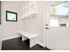 The mud room offers convenient storage with a built-in bench, hooks, and cubbies, complemented by stylish black flooring at 1462 S Vine St, Denver, CO 80210