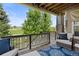 Spacious back deck with wicker chairs, blue cushions, and a view of the lush greenery and golf course at 7963 S Valleyhead Way, Aurora, CO 80016
