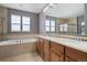 Bright bathroom with double sinks, tile floors, granite countertops, soaking tub and glass shower at 7963 S Valleyhead Way, Aurora, CO 80016