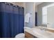 Bathroom featuring shower-tub combination, wood vanity and blue shower curtain at 7963 S Valleyhead Way, Aurora, CO 80016
