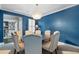 Elegant dining room featuring a blue accent wall, modern chandelier, and seating for six at 7963 S Valleyhead Way, Aurora, CO 80016