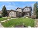 Charming two-story home with a stone facade, well-manicured lawn, and inviting front porch at 7963 S Valleyhead Way, Aurora, CO 80016