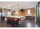 Spacious kitchen with a marble island, brick accent wall, bar stool seating, and wine fridge at 7963 S Valleyhead Way, Aurora, CO 80016