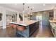 Open concept kitchen with a large island, brick accent wall, stainless steel appliances, and bar stool seating at 7963 S Valleyhead Way, Aurora, CO 80016