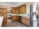 Well-lit kitchen with stainless steel appliances, wood cabinetry, and modern countertops at 7963 S Valleyhead Way, Aurora, CO 80016