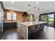 Beautiful kitchen featuring a large island with seating, exposed brick accent wall, and stainless steel appliances at 7963 S Valleyhead Way, Aurora, CO 80016