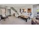 Bright and spacious living room featuring a large sectional sofa, staircase, and open layout to the kitchen at 7963 S Valleyhead Way, Aurora, CO 80016