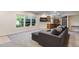 Open-concept living room featuring large windows, modern sofa, and a convenient kitchenette at 7963 S Valleyhead Way, Aurora, CO 80016