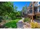 Landscaped backyard with a stone path and stairs leading to a deck surrounded by lush greenery at 20460 Oakbrook Ln, Parker, CO 80138