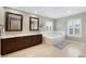 Bright bathroom featuring double vanity, soaking tub, light tile flooring, and shuttered windows at 20460 Oakbrook Ln, Parker, CO 80138