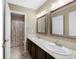 Bright bathroom featuring a double sink vanity with granite countertop and framed mirrors at 20460 Oakbrook Ln, Parker, CO 80138