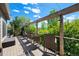 Outdoor deck with seating and a wooden pergola, showcasing a serene view of surrounding trees at 20460 Oakbrook Ln, Parker, CO 80138