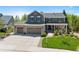 Charming two-story home with a three-car garage, stone accents, a manicured lawn, and mature trees at 20460 Oakbrook Ln, Parker, CO 80138