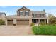 Inviting two-story home featuring a three-car garage, stone accents, and a well-manicured lawn at 20460 Oakbrook Ln, Parker, CO 80138