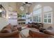 Comfortable living room with a stone fireplace, tall ceilings, and plentiful natural light through shuttered windows at 20460 Oakbrook Ln, Parker, CO 80138