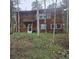 View of cabin-style home on a wooded lot with a covered front porch and rustic charm at 10314 Red Fern Trl, Conifer, CO 80433