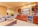 Basement bar area complete with a beverage fridge, cabinets, and a seating area at 5090 S Perry Park, Sedalia, CO 80135