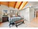 Cozy bedroom with a wooden ceiling, a wrought-iron bed, soft lighting, and views of the outdoors at 5090 S Perry Park, Sedalia, CO 80135