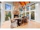 Elegant dining room with a stone fireplace, chandelier, wood beam ceiling, and large windows showcasing a wooded view at 5090 S Perry Park, Sedalia, CO 80135