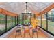 Greenhouse interior with bistro seating and a view of wooded property at 5090 S Perry Park, Sedalia, CO 80135