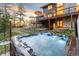 Hot tub with water feature, set against the backdrop of a two-story home and trees at sunset at 5090 S Perry Park, Sedalia, CO 80135