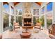 A cozy living room boasts a stone fireplace, floor to ceiling windows, and hardwood floors at 5090 S Perry Park, Sedalia, CO 80135