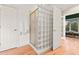 Bathroom showing a glass block shower with gold trim, wood floors and two white doors at 5090 S Perry Park, Sedalia, CO 80135